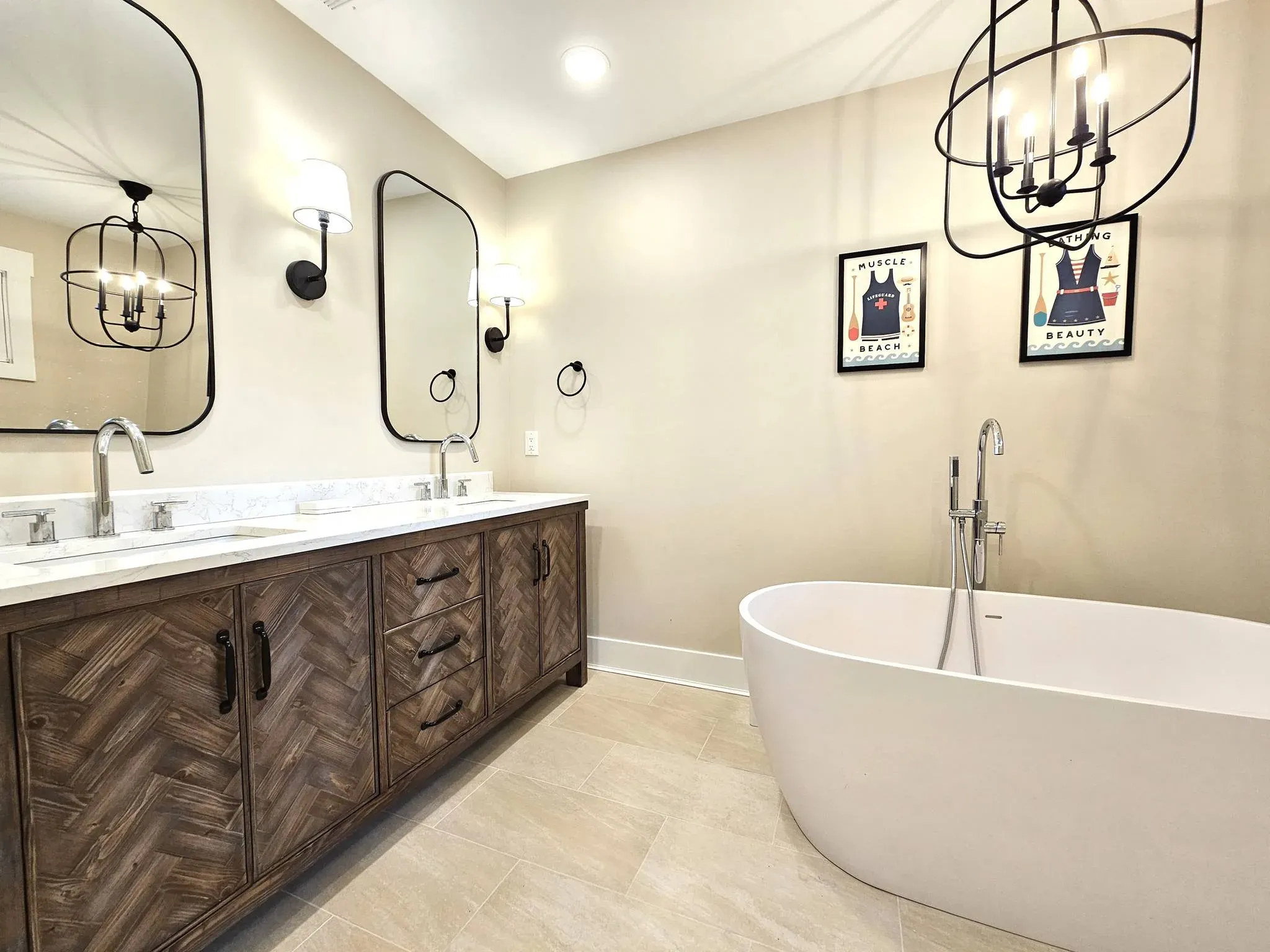 Bathroom with herringbone wood vanity, double sinks, freestanding tub, and framed beach prints